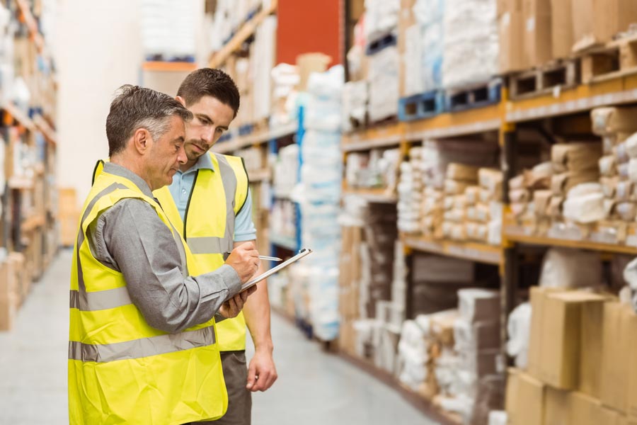 two men looking at clipboard in warehouse
